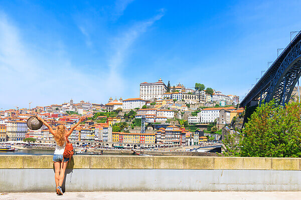 panorama view of porto cityscape, old town and dom luis bridge with woman traveler portugal